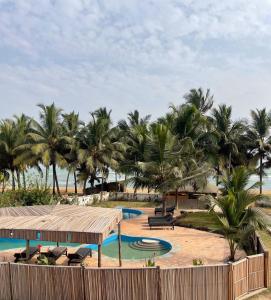 AnkwandaAfiki的海滩上带游泳池和棕榈树的度假村