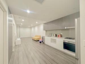 悉尼Burwood Cozy Apartment Free Parking的厨房配有白色橱柜和沙发