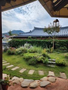 全州市Jahayeon Hanokstay的屋顶建筑前的花园