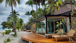 班柯木穆岛西拉威海滩度假酒店的海滩上的房子,长椅和棕榈树
