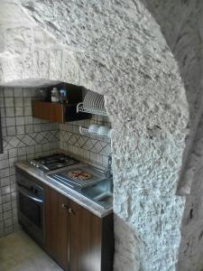 阿尔贝罗贝洛迪莫拉玛塔乐思特鲁利住宿加早餐酒店的厨房设有石墙和炉灶