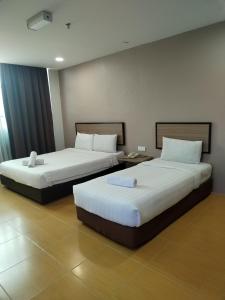 Kota BharuMaple Boutique Hotel Kota Bharu的两张位于酒店客房的床,配有两张sidx sidx单人床