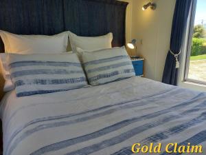 CharlestonCharleston Goldfields Accommodation的一张带蓝色和白色棉被的床和一个窗口