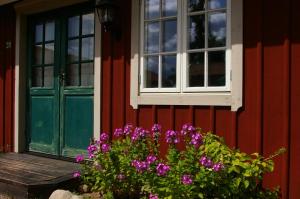维默比欧克斯戈登酒店的红色的房子,有绿门和紫色的鲜花