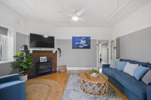 奥兰治Bluestone Cottage - Character & Class的客厅配有蓝色的沙发和电视
