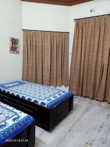 乌代浦Gokulam Villa的带窗帘的客房内的两张单人床