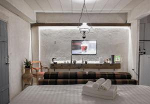 乌汶德亮旅馆的一间卧室配有一张床、一张沙发和一台电视。