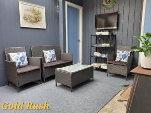 CharlestonCharleston Goldfields Accommodation的客厅配有两把椅子和电视