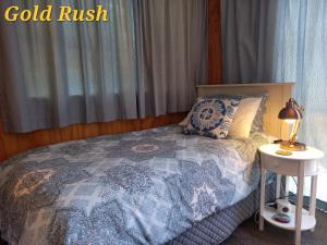 CharlestonCharleston Goldfields Accommodation的一间卧室配有一张床和一张桌子上的台灯