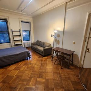 纽约New York City Guest House 2的一间卧室配有一张床、一张桌子和一张沙发