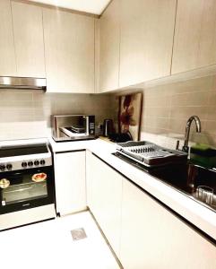 阿布扎比Yas Island canal 1- Formula 1, Entertainment, and Luxury Living!的厨房配有白色橱柜、炉灶和水槽。