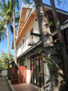琅勃拉邦Luangprabang Villa bouathong Hotel的前面有棕榈树的房子