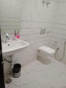 新德里Hotel Mannat International at Paschim Vihar的白色的浴室设有水槽和卫生间。