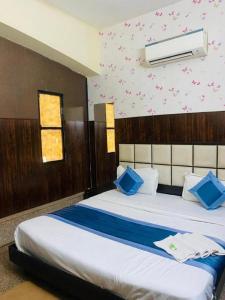新德里Hotel Mannat International at Paschim Vihar的一间卧室配有一张带蓝色枕头的大床