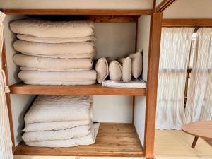 镰仓市江ノ電の線路沿いにある宿【film koshigoe】的木架上的一大堆毛巾
