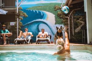 阳光海岸努沙弗拉希帕克斯酒店的一群人和一只狗在游泳池里