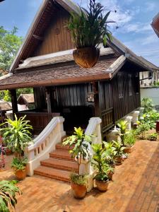 琅勃拉邦Villa Phathana Royal View Hotel的前面有盆栽的小房子