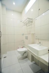 根尼亚古马里LK.Lodge的白色的浴室设有卫生间和水槽。