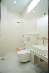 根尼亚古马里LK.Lodge的白色的浴室设有卫生间和水槽。