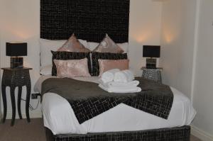 博克斯本森之家博克斯酒店的一间卧室配有一张带两盏灯的黑白床。