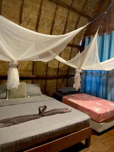 高兰Lanta Marina Resort By Mam&Mod的一间卧室配有两张床和蚊帐