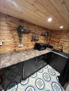 卡德纳姆Cozy Cottage with hot tub!的厨房设有台面和木墙