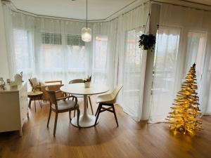 EcublensAppartement calme et lumineux de 2,5 pces proche Lausanne的一间设有桌子和圣诞树的用餐室