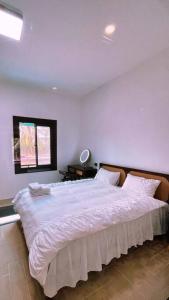 琅勃拉邦Wooden House on lake,city center的卧室配有一张大白色床和窗户