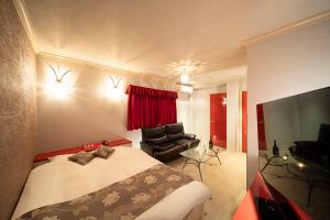 神户ホテル リベラル 男塾ホテルグループ的一间卧室配有一张床、一把椅子和电视