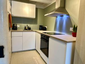 维尔扬迪Romantic hideout with parking的厨房配有白色橱柜和炉灶烤箱。