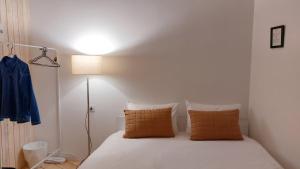Nature Rooms-Cozy Cabin in the Woods的一间卧室配有带白色床单和橙色枕头的床。