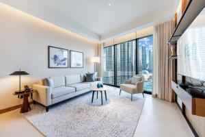 迪拜FAM Living - Burj Khalifa Bliss: Address Opera Modern 2BR的带沙发和电视的客厅