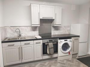 布赖尔利希尔Local to Russells Hall Hospital的厨房配有白色橱柜和洗衣机。
