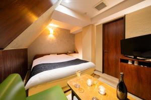 神户ホテル トランス 男塾ホテルグループ的一间卧室配有一张床、一张桌子和一台电视。