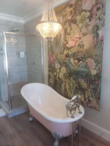 开普敦Thyme Wellness Spa and Guesthouse的一间带吊灯和浴缸的浴室