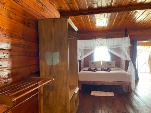 俊穆岛俊穆岛瑞莱克斯海滩旅馆的小木屋内一间卧室,配有一张床