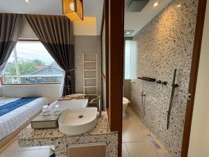 怡保Muzi Boutique Hotel的一间带床、水槽和淋浴的浴室