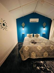 卡纳科纳LAKSHDEEP COTTAGES的一间卧室配有一张带蓝色墙壁的大床
