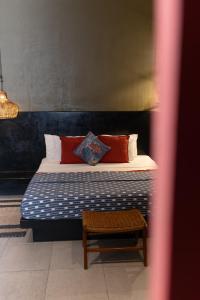 坎古Wasabi的一间卧室配有一张带枕头和桌子的床