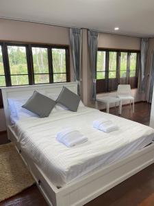 班昌Paradise Pool Villa at My Second home的卧室配有一张带两个枕头的大白色床