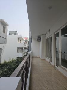 古尔冈Place to stay in Gurugram的白色建筑的阳台,带走道