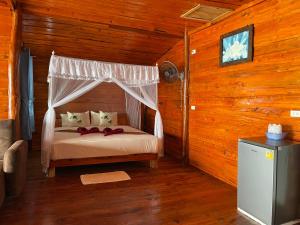 俊穆岛俊穆岛瑞莱克斯海滩旅馆的小木屋内一间卧室,配有一张床