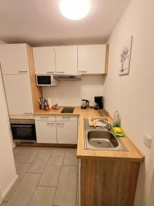 阿沙芬堡Apartment/Wohnung direkt in Aschaffenburg的一个带水槽和白色橱柜的小厨房