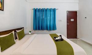 莫尔吉姆FabExpress Aqua Vista的一张大床,位于一个蓝色窗帘的房间
