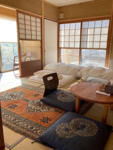 德岛小舞庵 Komaian的客厅配有桌子和地毯。
