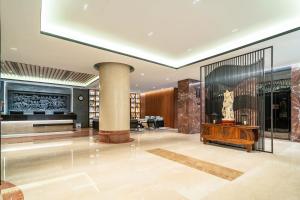 上海上海中星君亭酒店的大堂设有大房间,配有圆柱和桌子