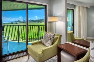 利胡埃OUTRIGGER Kaua'i Beach Resort & Spa的酒店客房设有带桌椅的阳台。