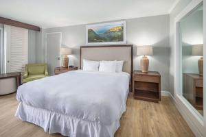 利胡埃OUTRIGGER Kaua'i Beach Resort & Spa的卧室配有一张白色大床和一把椅子