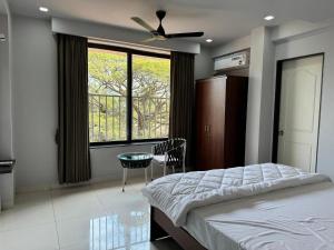 帕纳吉Balaji Inn Guest House, Panjim的一间卧室配有一张带吊扇和窗户的床。