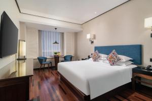 上海上海中星君亭酒店的酒店客房设有一张白色大床和一张桌子。